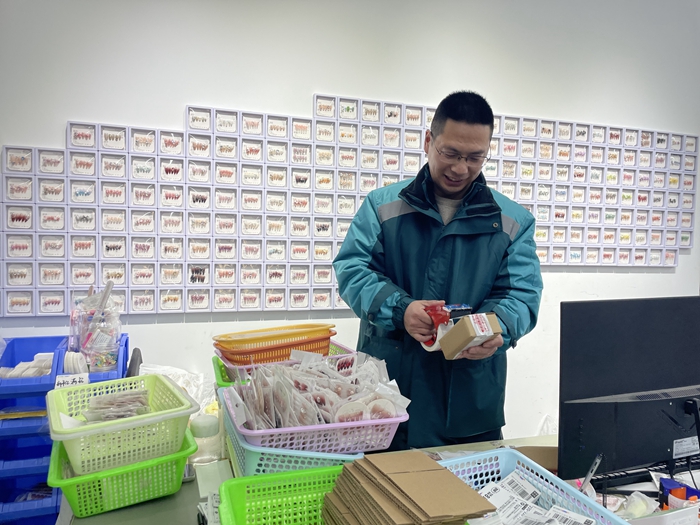 邮政工作人员协助客户打包穿戴甲邮件。江苏邮政供图